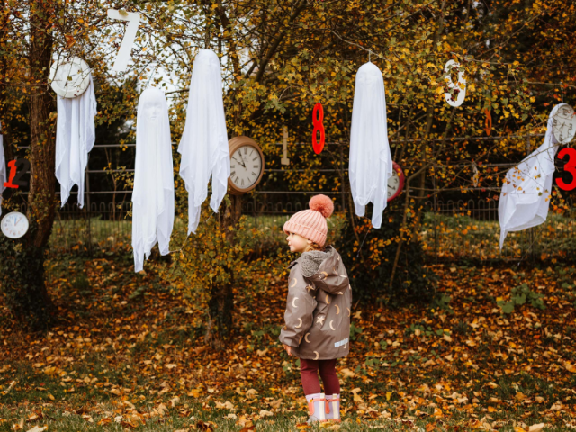 Halloween at Boughton girl stood among the trees surrounded by halloween decorations